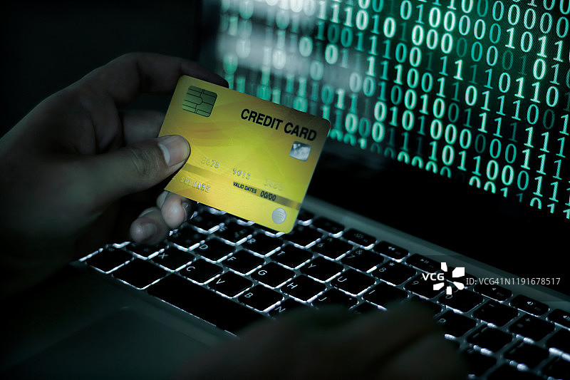 信用卡盗窃概念。用笔记本电脑上的信用卡进行非法购物的黑客图片素材