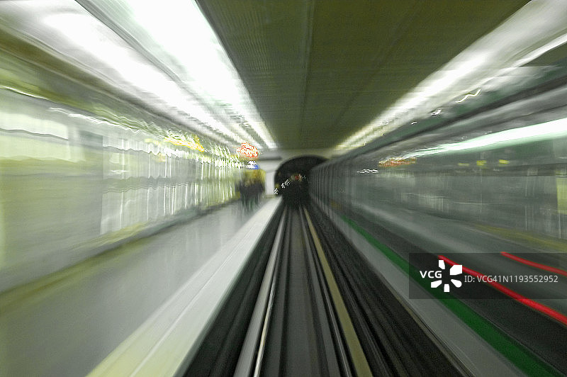 长时间曝光的巴黎地铁(地铁，地下)列车的运动，从后面的列车员车厢拍摄的出站，而其他列车正在到达相反的方向图片素材