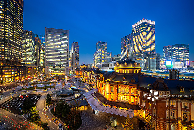 黄昏时分的东京火车站和东京市区高层商务办公大楼。日本旅游，现代城市生活，或商业金融和经济概念图片素材