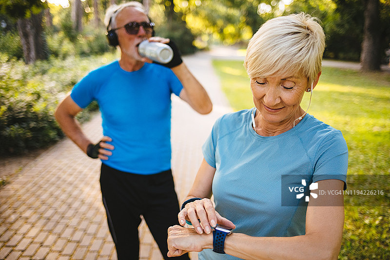 老年女性在户外运动时使用智能手表图片素材