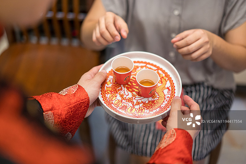 新婚夫妇在中国传统茶道上给老人斟茶图片素材