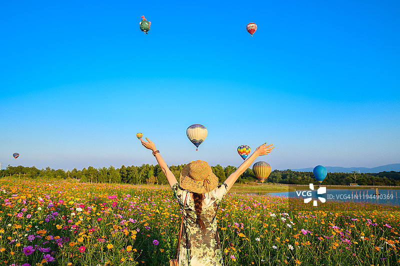 年轻的女游客参观宇宙花田和看热气球节在泰国清莱省的背影。图片素材