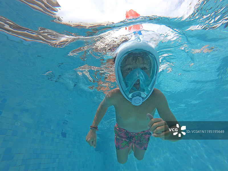 男孩在游泳池跳水的水下镜头图片素材