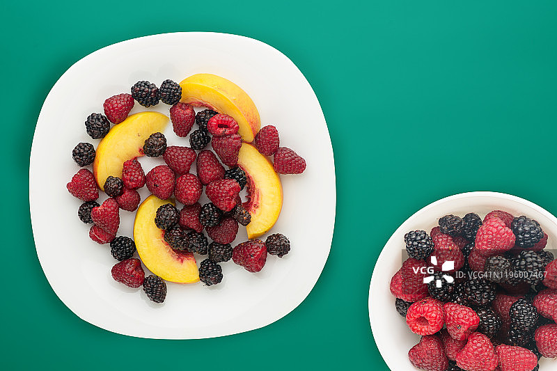 饮食,健康食品。黑莓、覆盆子、油桃放在盘子里的白色盘子里。素食食物的背景俯视图。图片素材