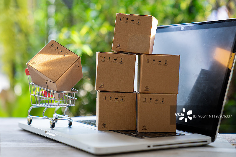 纸板boxe。网上销售的概念、网上购物和网上购物。通过互联网实现商品和服务。买卖货物。图片素材