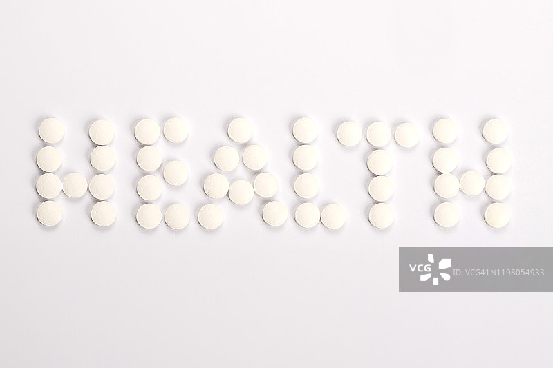 健康字由白色的药片在白色的背景图片素材