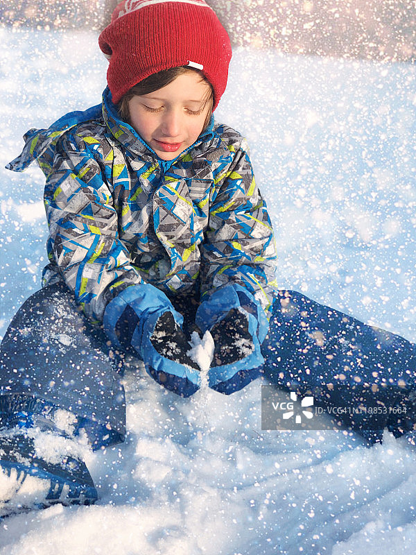 小男孩在雪中玩耍图片素材