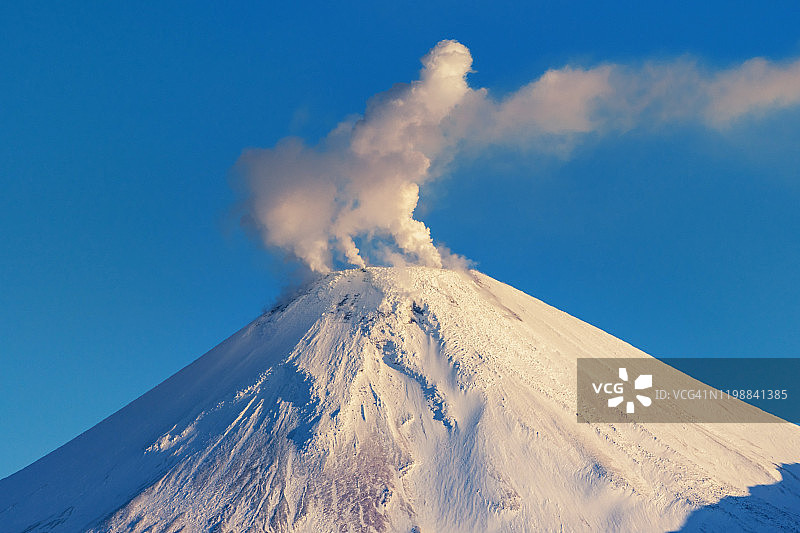 堪察加半岛的冬季火山景观:活火山阿瓦查火山，火山喷气口活动——早晨日出时从火山口喷出的蒸汽、气体和火山灰云图片素材