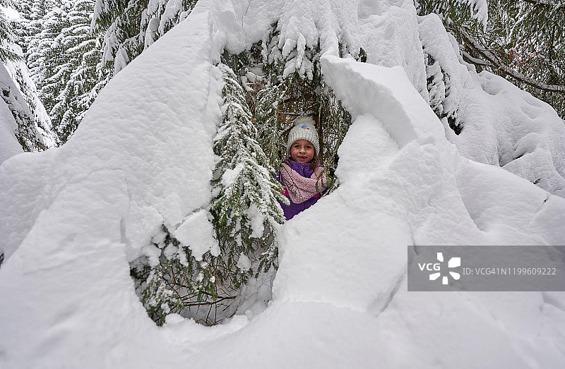 小女孩在罗马尼亚特兰西瓦尼亚的森林徒步旅行中享受冬天的雪。图片素材