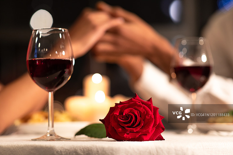 桌上的玫瑰，餐厅里的情侣手牵着手图片素材