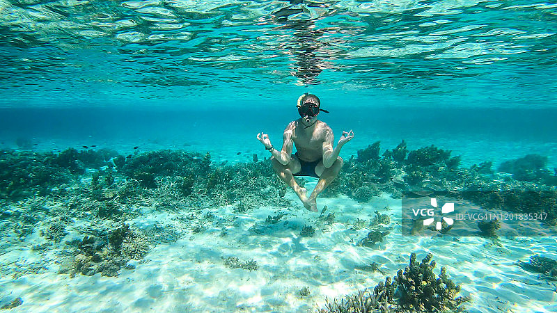 科莫多-一个人浮潜在珊瑚礁上图片素材