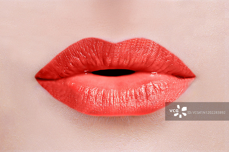 性感的白人女人完美的嘴唇与红色唇膏发送一个吻或低语的特写图片素材