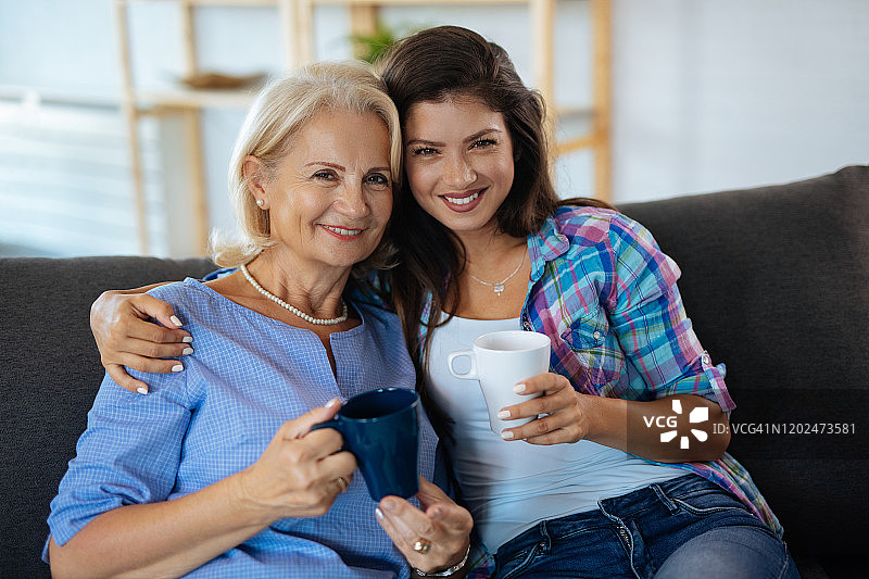 一位年轻女子和她的母亲一起享受着一杯咖啡图片素材