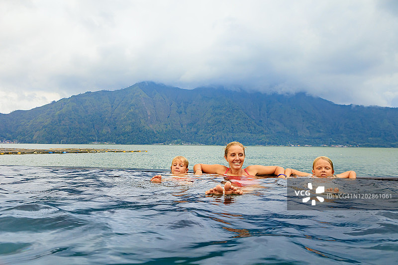 巴图尔火山温泉的幸福家庭。图片素材
