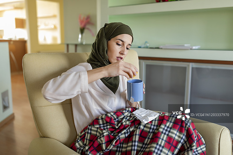 生病的穆斯林妇女喝着柠檬茶图片素材