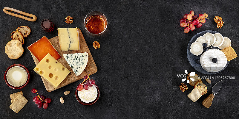 奶酪全景。山羊奶酪，布里干酪，蓝奶酪和其他，从顶部拍摄的黑色背景和文字的地方图片素材