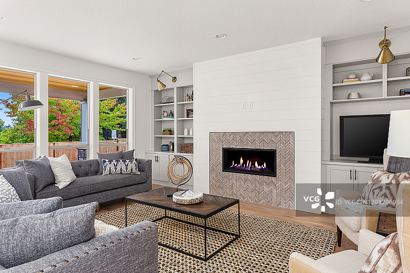 美丽的客厅内部与硬木地板和壁炉在新的豪华的家图片素材