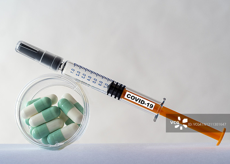 接种:注射covid-19冠状病毒疫苗和治疗症状的药片。图片素材