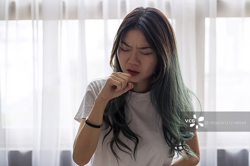 年轻的亚洲妇女咳嗽和生病的流感和感冒图片素材