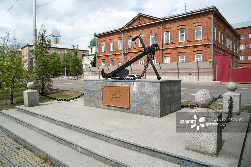 这座锚形纪念碑是为了纪念叶尼塞河上航行100周年，背景是内务部大楼。俄罗斯克拉斯诺雅茨克。图片素材