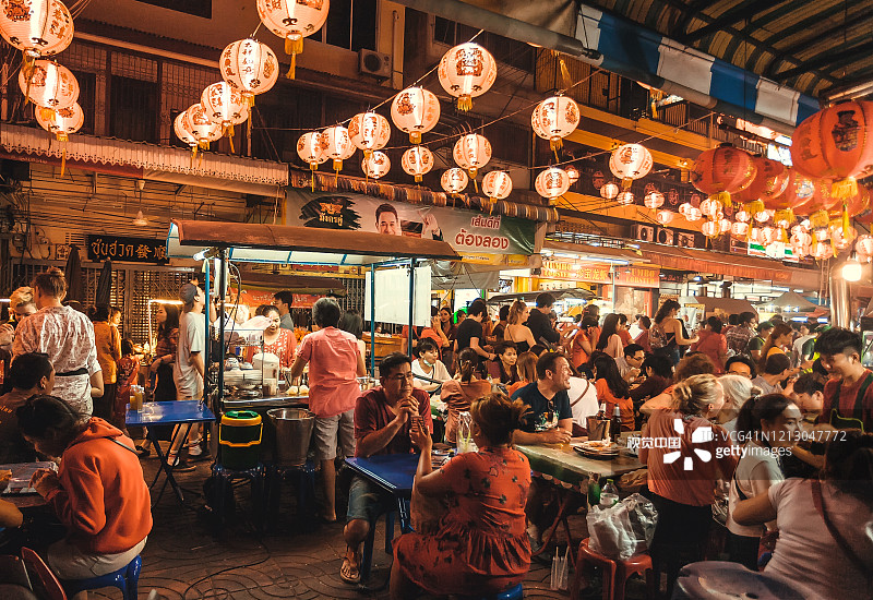 晚上，人们在唐人街的街边餐馆里见面、聊天、吃亚洲菜图片素材