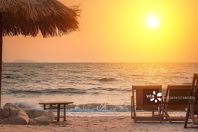 日落时在海滩上的沙滩椅，日出时在荒芜的海岸上的沙滩躺椅。图片素材