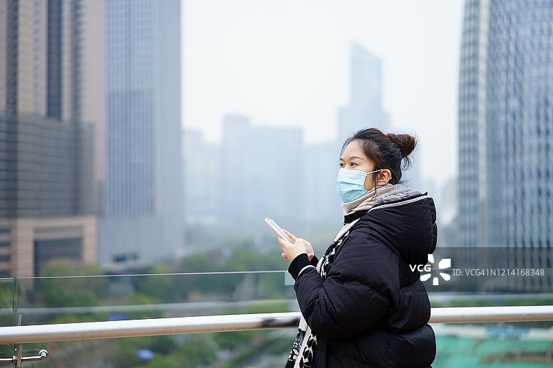 亚洲妇女戴着防护面罩在街上图片素材
