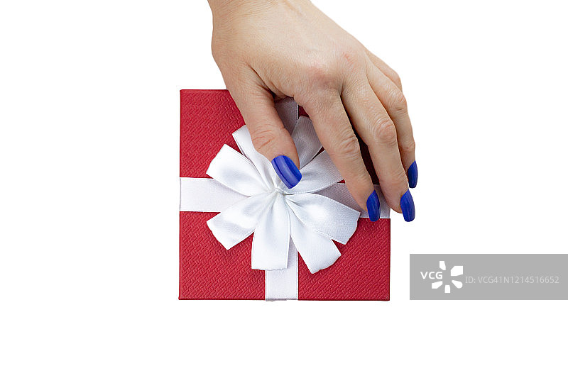 女性手在红色礼盒上，白色丝带，蓝色指甲孤立在白色背景上。关闭了。以上图片素材