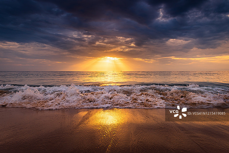 美丽的日落风景与运动海滩上的巨浪，热带海洋和戏剧性的天空丰富多彩的安达曼海海滩。图片素材