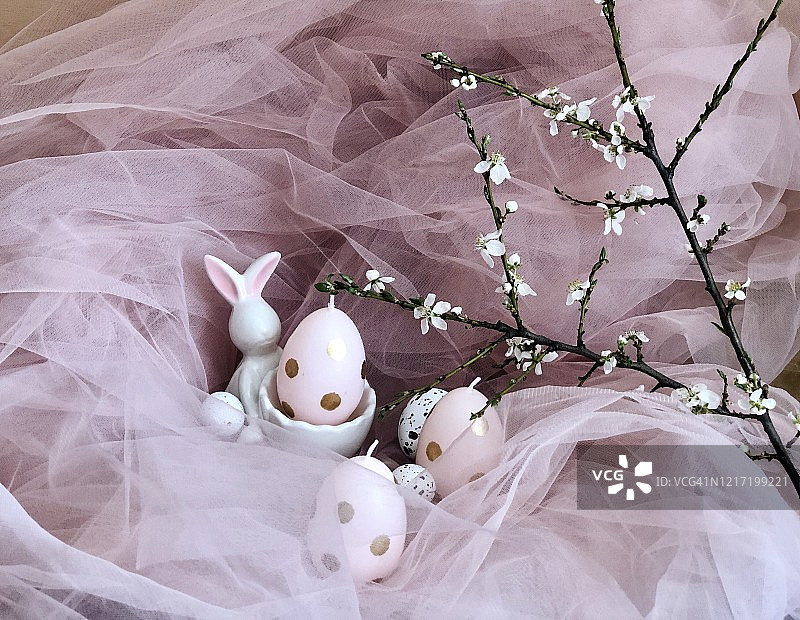粉红色的复活节背景与复活节兔子和鸡蛋与白色的春天的枝花图片素材