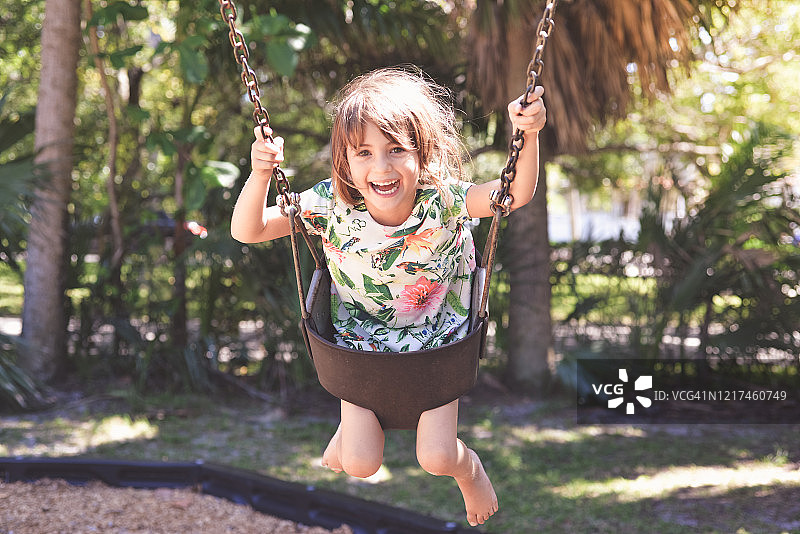 可爱的快乐的四岁的荡秋千微笑和幸福的喜悦图片素材