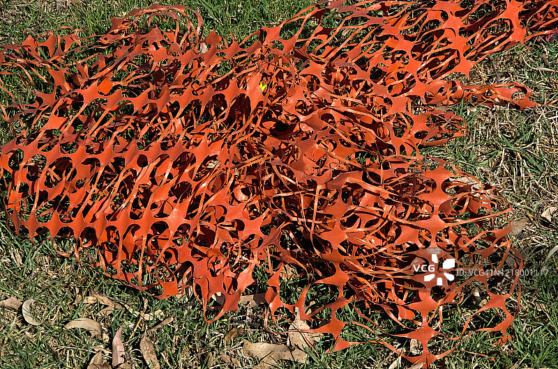 草坪上的橙色塑料防护网坍塌了图片素材