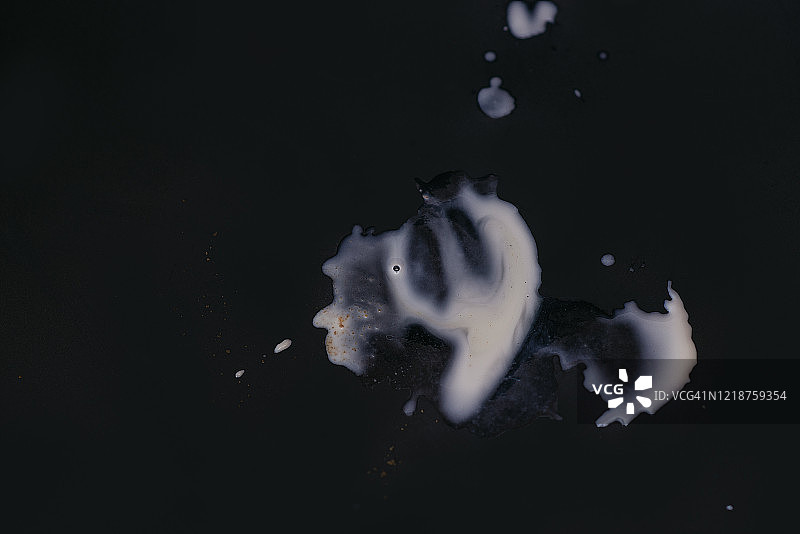 牛奶污渍洒在黑色的桌子上图片素材