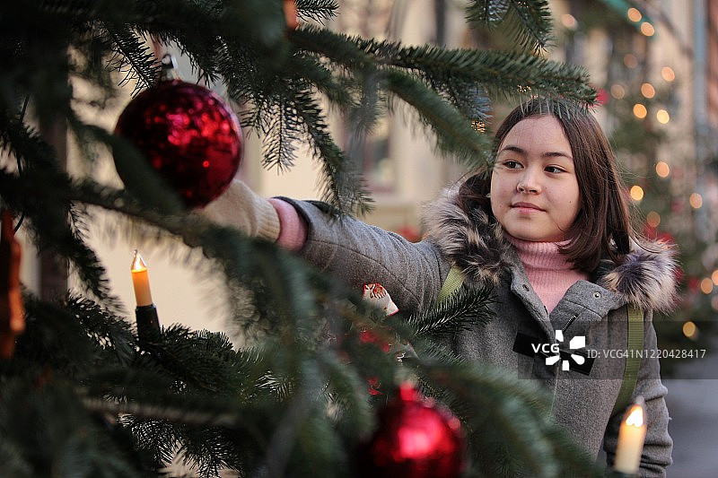 一个小女孩和圣诞树的肖像图片素材