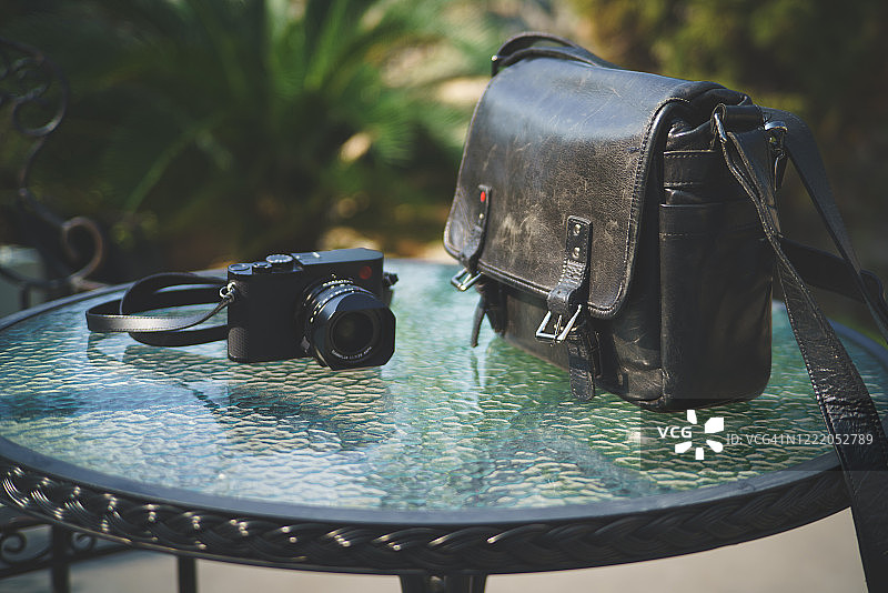 黑色的相机和相机袋在花园里图片素材
