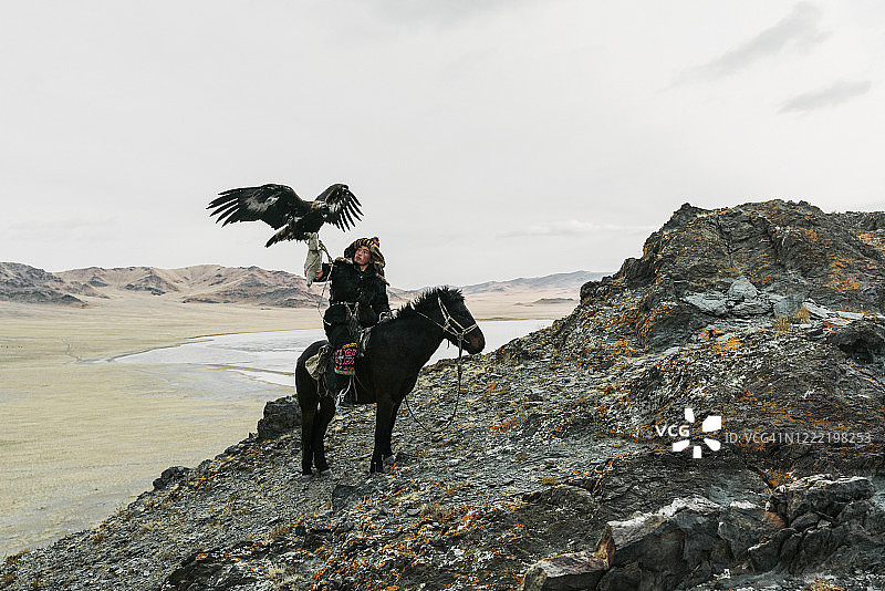 蒙古沙漠中骑着马的猎鹰者图片素材