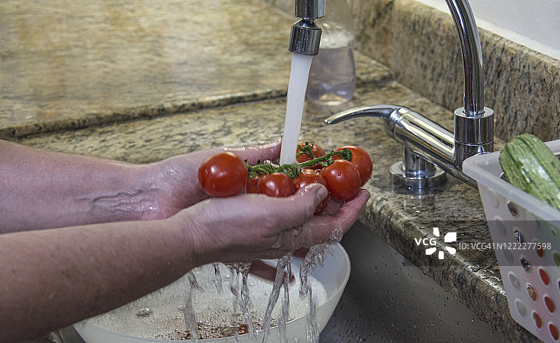 特写的手，洗蔬菜在家庭厨房水槽图片素材
