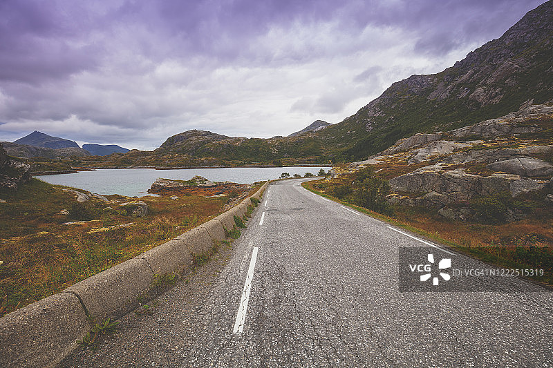 蜿蜒的道路沿着山脉和峡湾，斯堪的纳维亚风景。挪威美丽的自然风光图片素材