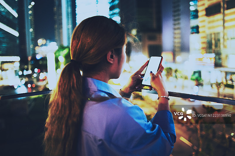 女商人晚上在市中心查看手机图片素材