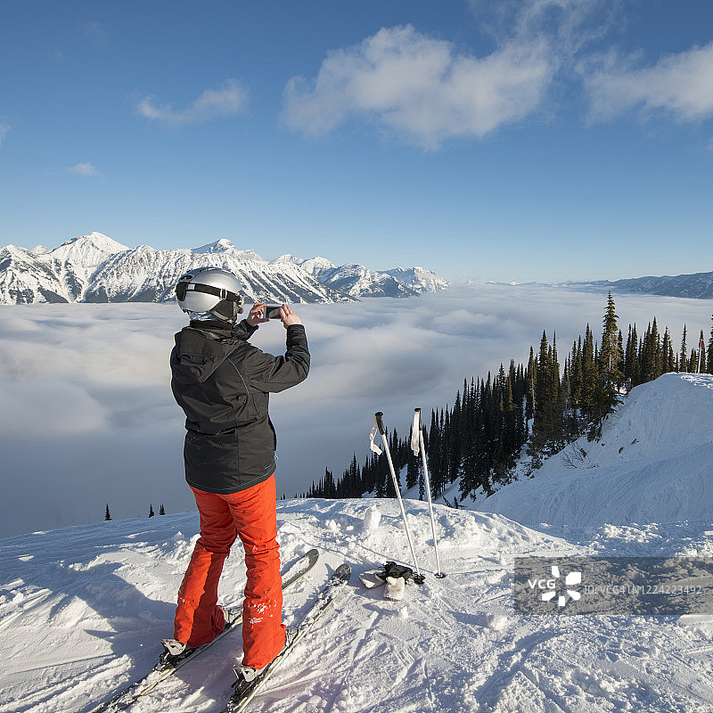 高山滑雪者放松在雾堤，山脉和山谷图片素材