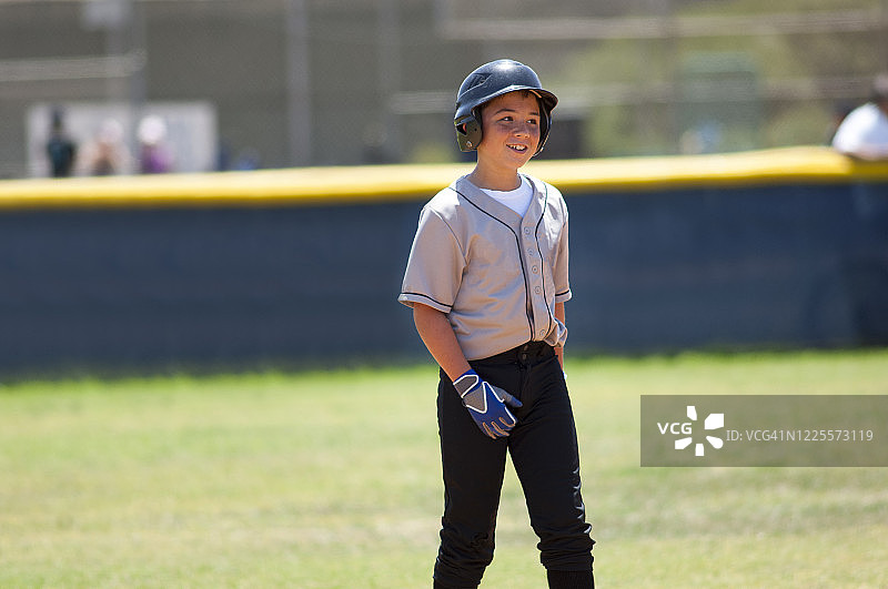 戴着棒球帽微笑的小联盟球员图片素材