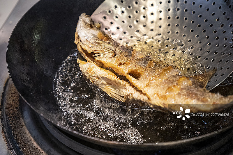 在铸铁锅里涂油炸鱼图片素材