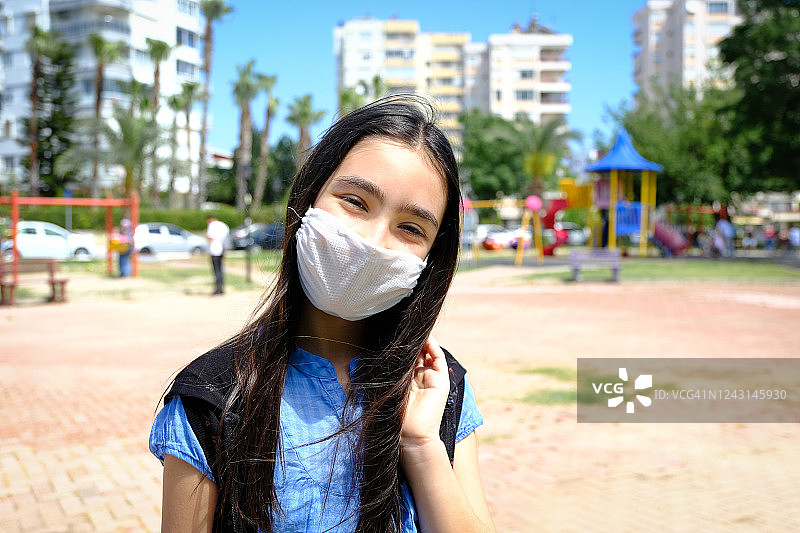 小女孩戴着防护面具在公园里图片素材