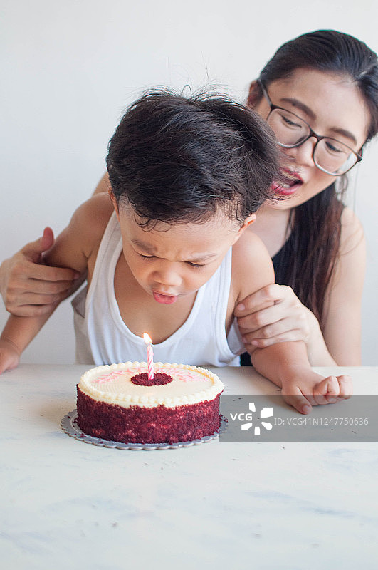 东南亚母亲和儿子在家里庆祝生日图片素材
