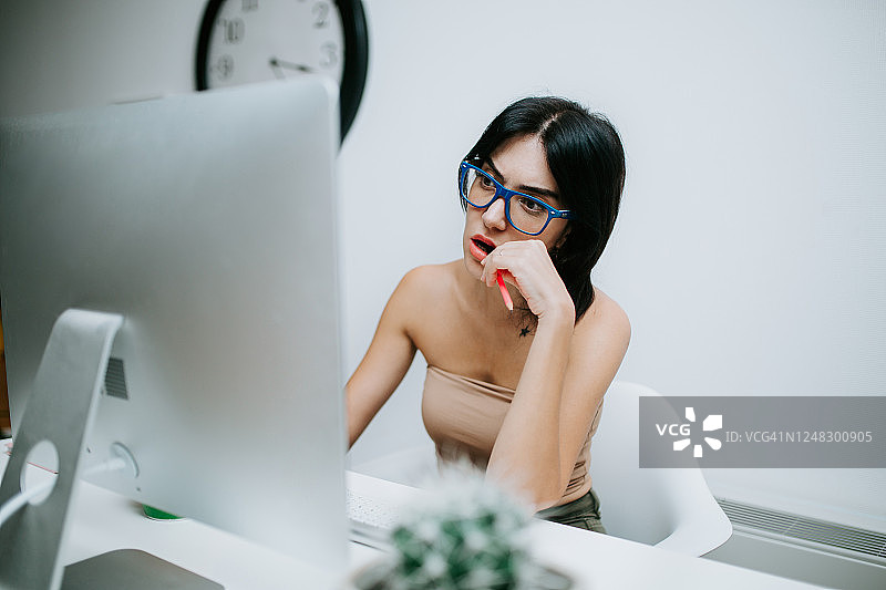 戴蓝眼镜在家用电脑工作的女人图片素材