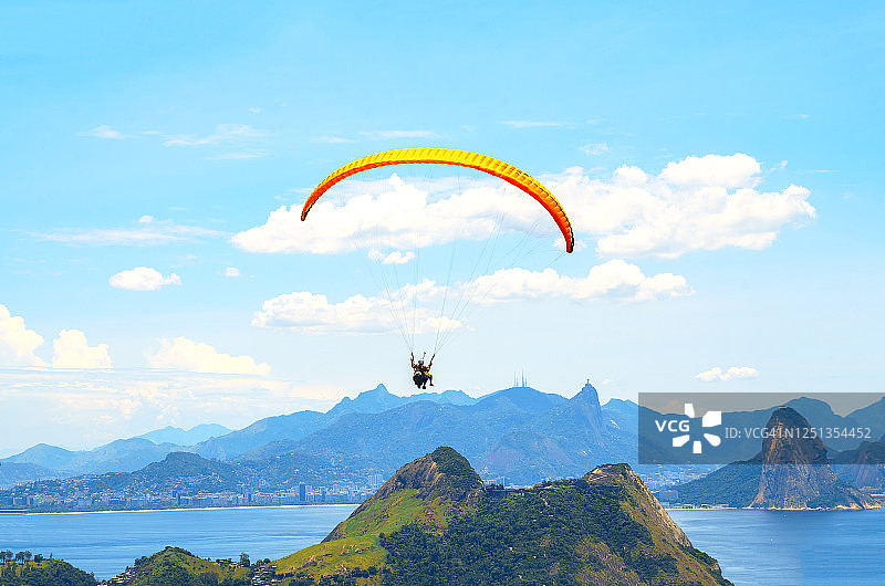 一个彩色的降落伞与跳伞者在阳光明媚的蓝天背景。积极的生活方式。极限运动。暑假、度假、旅游的概念。图片素材