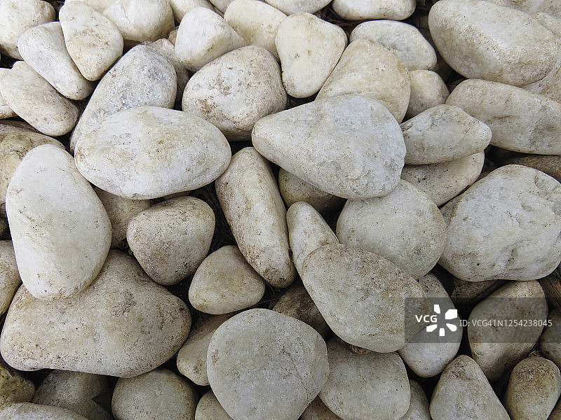 背景的白色鹅卵石石头在他们的自然状态不同的大小和形状。一种砾石石在院子里的花纹和纹理。图片素材