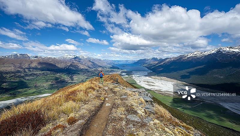新西兰南岛奥塔哥，南阿尔卑斯山脉附近的格伦诺奇，阿尔弗雷德峰上的徒步旅行者，欣赏瓦卡蒂普湖和山景图片素材