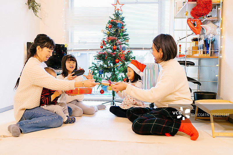 家人一起在家玩圣诞礼物交换游戏图片素材