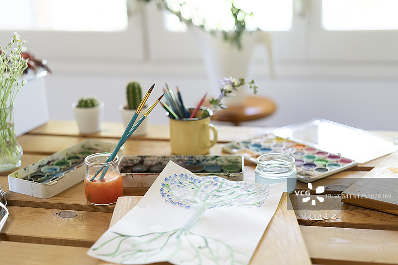 水彩颜料用素描和画笔放在木桌上回家图片素材